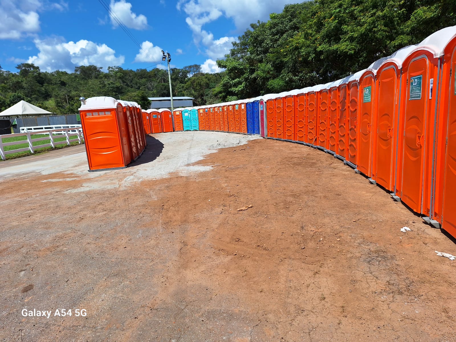 Banheiro químico masculino com porta azul e sinalização